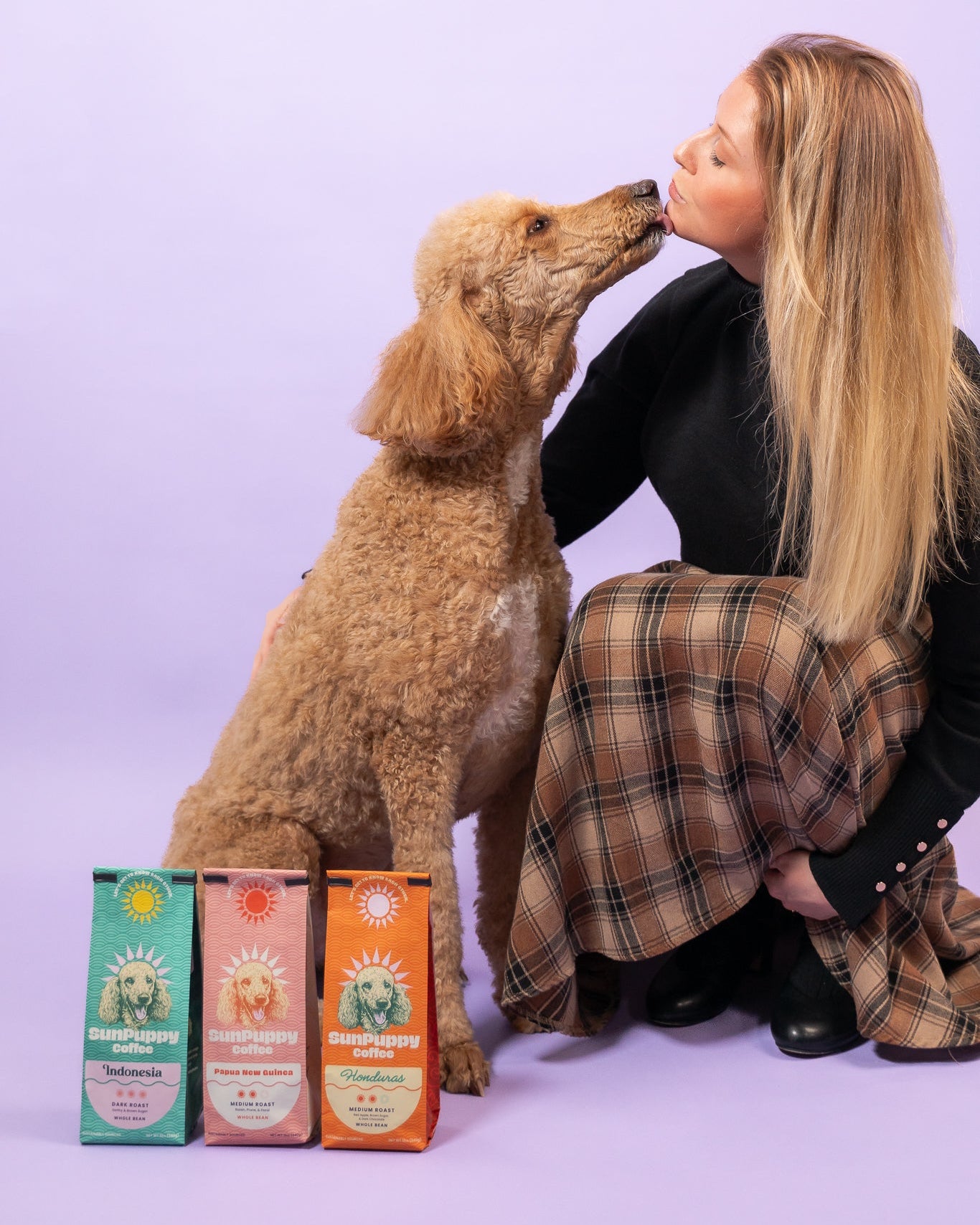 Woman and dog with pet food boxes on a light purple background