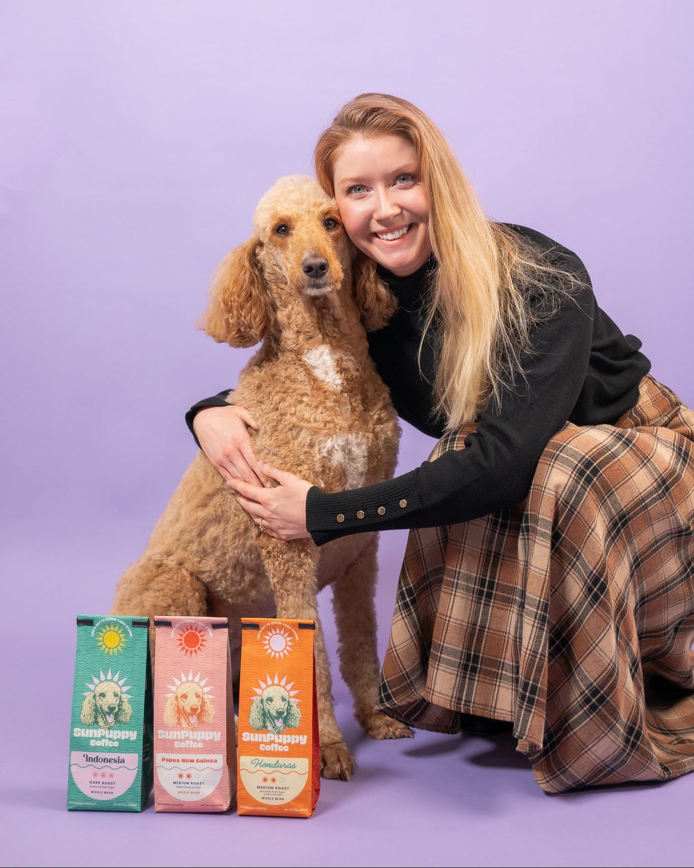 Woman with a dog and pet product boxes on a purple background