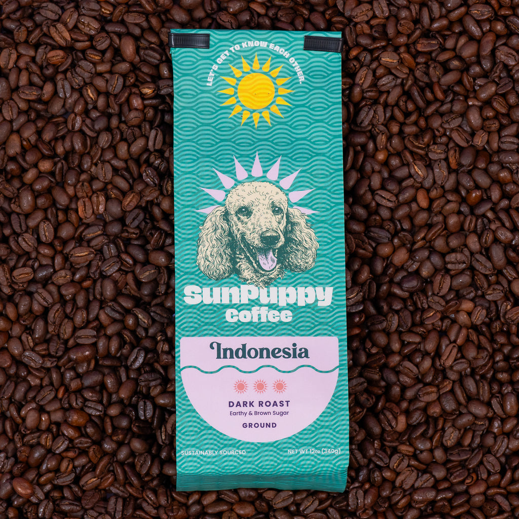 Sunpuppy Coffee Indonesian dark roast ground coffee in teal turquoise packaging featuring standard poodle mascot with sun logo on purple background 12 ounces