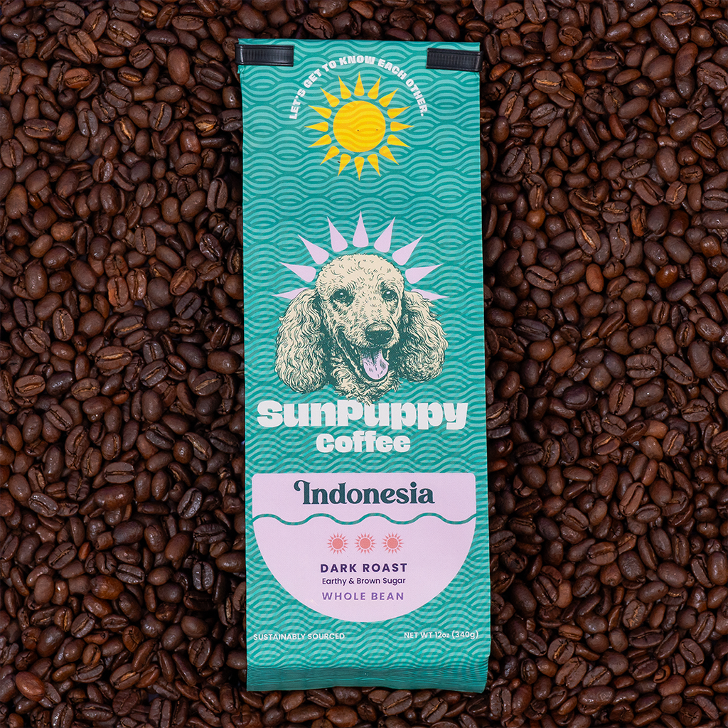 Sunpuppy Coffee Indonesian dark roast whole bean coffee in teal turquoise packaging featuring standard poodle mascot with sun logo on purple background 12 ounces